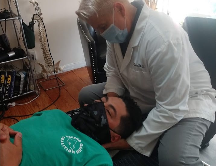 Dr. Lonna Denny performing a traditional neck adjustment to a patient.