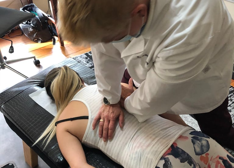 Dr. Lonna Denny performing a traditional spinal adjustment to a patient.
