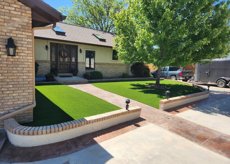 artificial turf in the front yard landscaping wrapped around a tree and on either side of a walkway