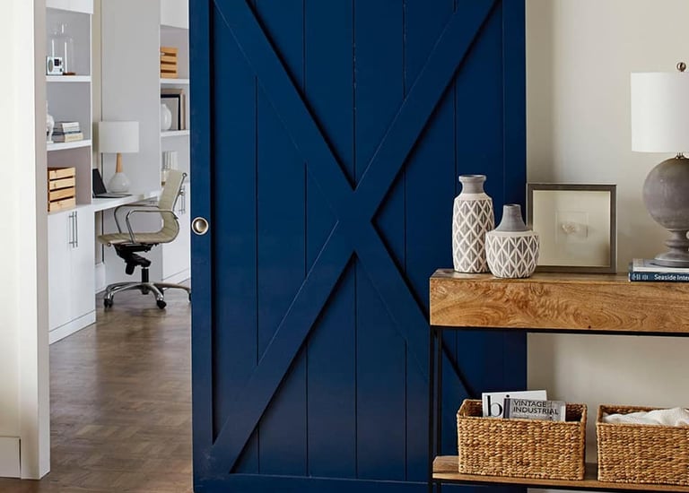 Large kitchen island with dark walnut wood countertop and white cabinetry on hardwood flooring.