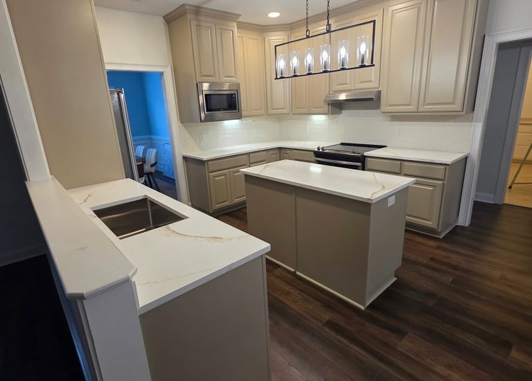 Modern kitchen remodel featuring beige cabinets, white quartz countertops, and a kitchen island.