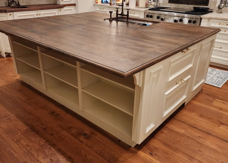 Custom kitchen island with dark walnut wood countertop, white cabinetry, and built-in shelving.