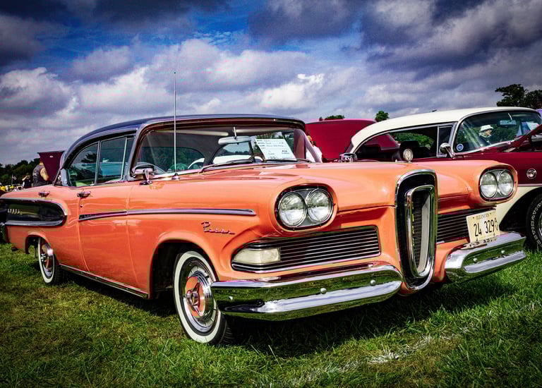 a vintage car parked in a grassy field