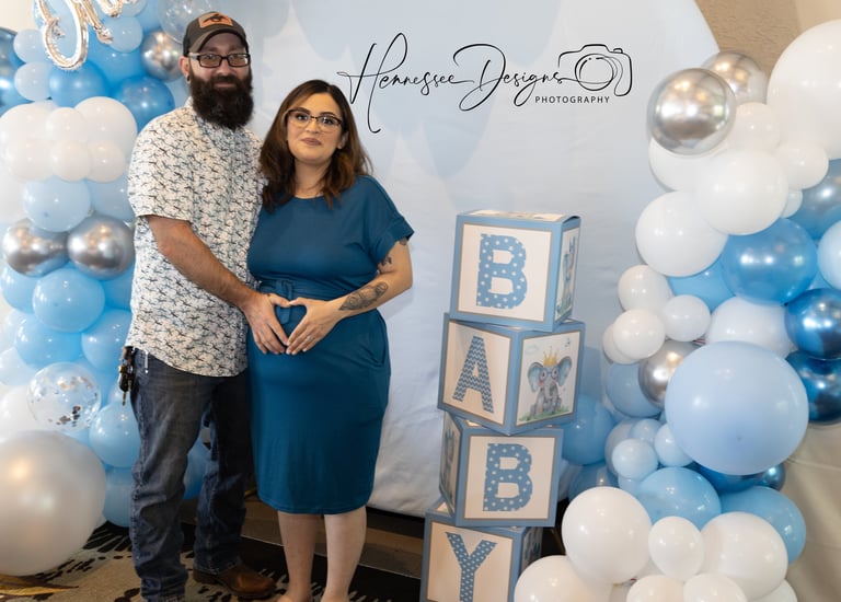 a man and woman standing in front of a baby shower