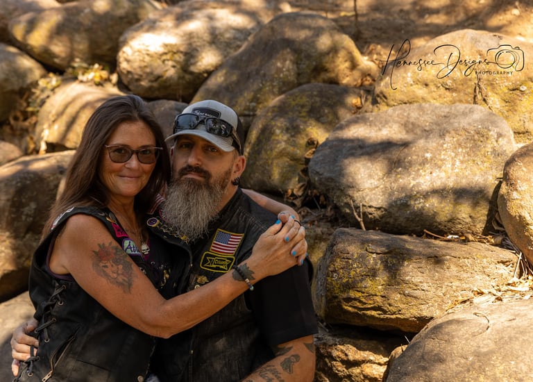 a man and woman sitting on a rock formation