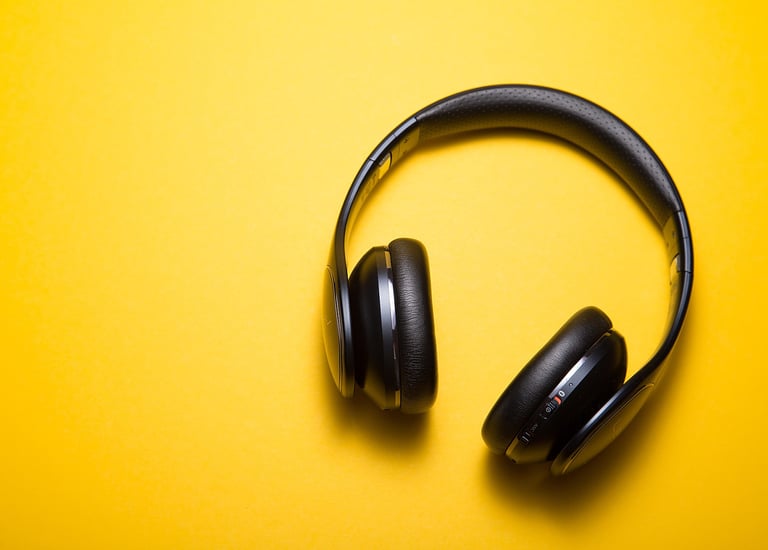 yellow background featuring a pair of black headphones