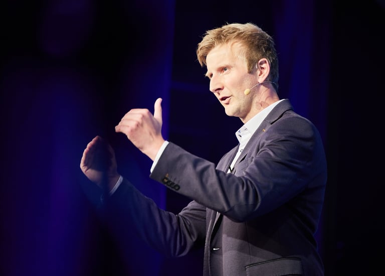 a man in a suit and tie is giving a speech