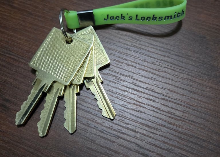A Jack’s Locksmith green key ring with golden keys attached representing a master key lock system