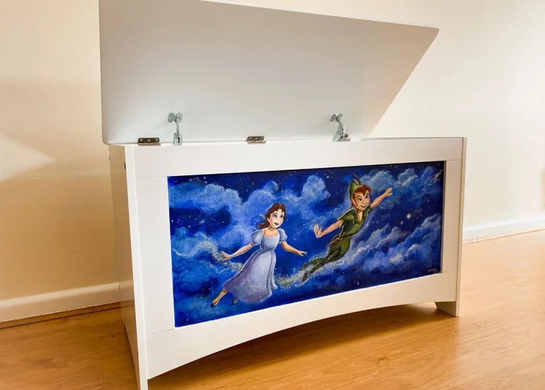 Angled white toy chest hand-painted with characters and a midnight blue, starry sky.