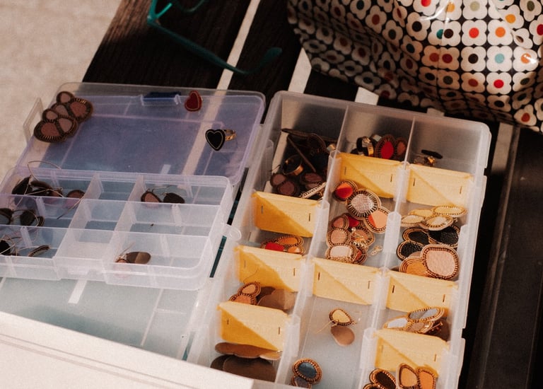 Des bijoux brodés rangés dans une boite à compartiments