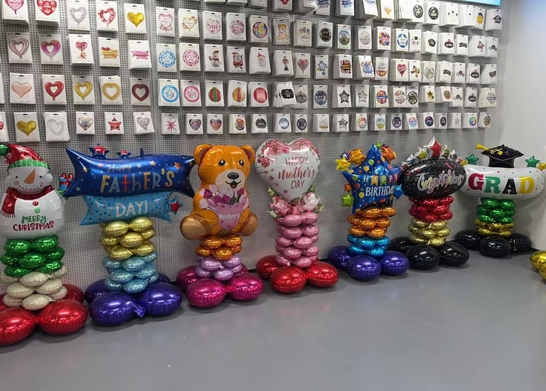 Colorful birthday party balloon display with Happy Birthday letters, a giant number 6, and a cupcake balloon.