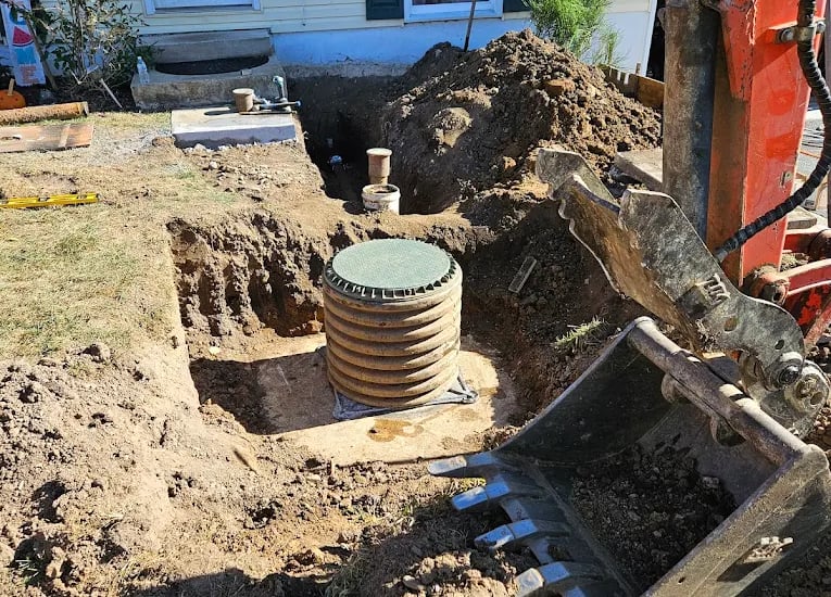 stormwater device in dirt next to excavating machine