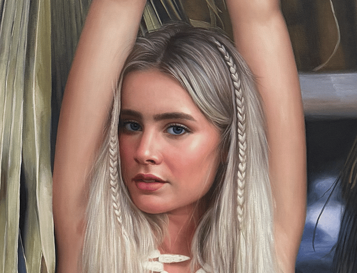 Portrait of a blonde woman with braided hair and a shell necklace against palm leaves.