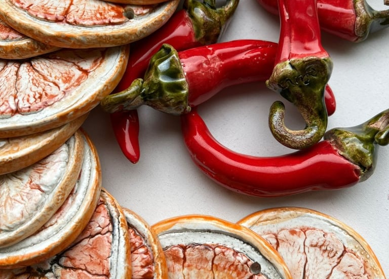 Handmade ceramic art inspired by nature with dried citrus and red chili peppers