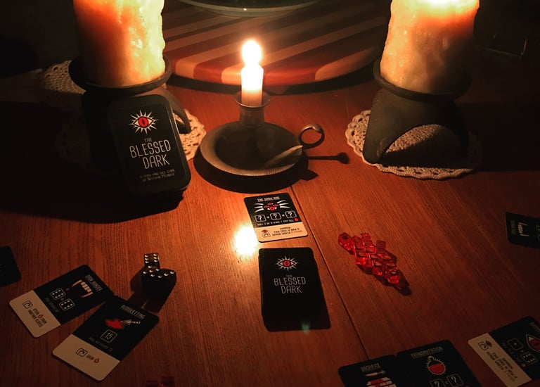 A creepy candle lit layout of The Blessed Darkl board game
