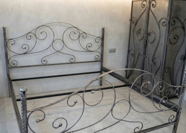 Ornate handcrafted wrought iron bed frame and matching metal armoire with scrollwork designs.