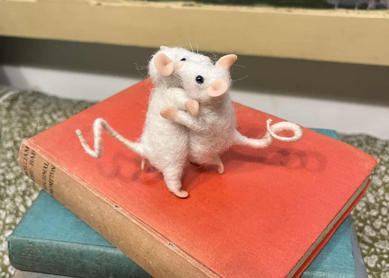 a mouse mouse sitting on top of a pile of books