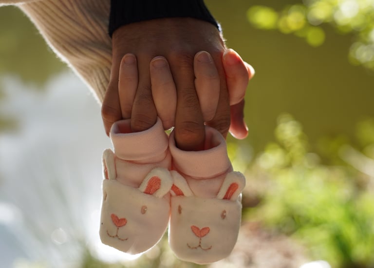 a person holding a pair of baby shoes