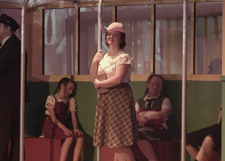 Character Young Catherine on a streetcar accompanied by younger siblings.