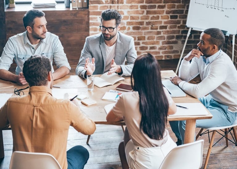 a group of people sitting around a table with papers and papers