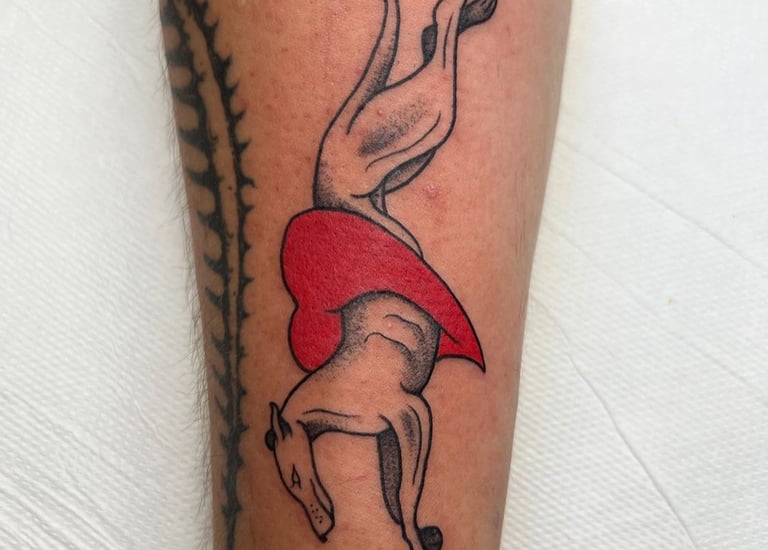 a tattoo of a dog jumping through a heart made at Inari Tattoo