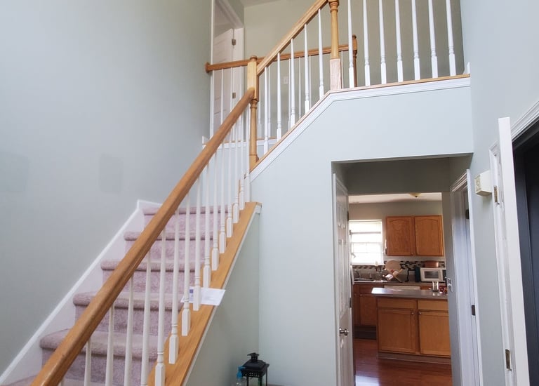 a painted foyer staircase way with a wooden stairs and wooden floor