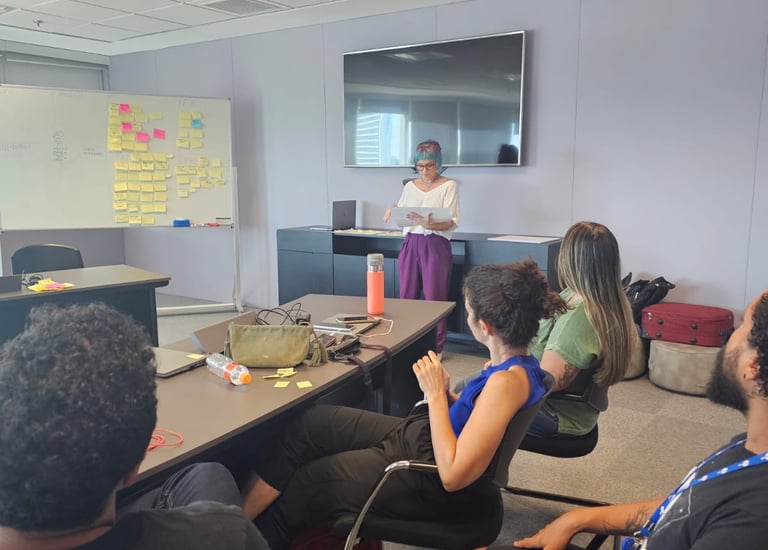 Gabriela Bechara Zillig conduz dinâmica de Design Sprint em uma sala de reunião para colegas