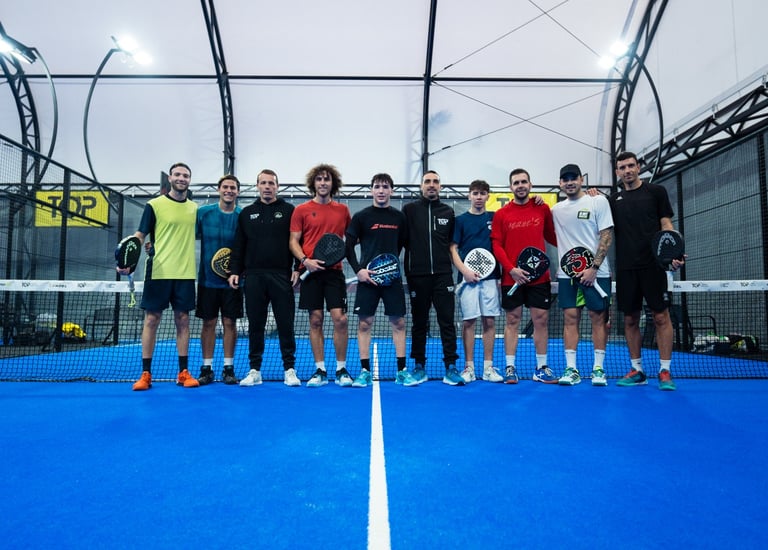 A group of padel players standing with rackets on a blue indoor court for a tournament team photo.