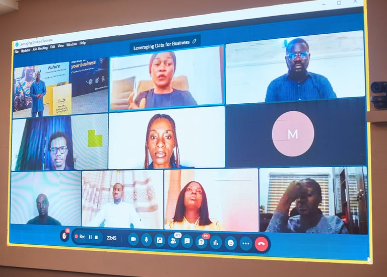 A virtual business meeting on a monitor featuring a video conference with multiple participants.
