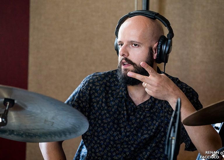 bruno tessele dando uma aula de bateria para um grupo de alunos