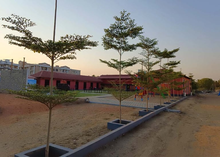 Hotel exterior featuring lush green design for guest relaxation by Garden Designers