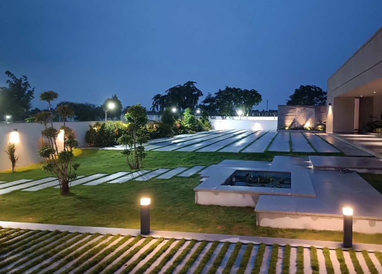 Garden lighting illuminating plants and walkways at dusk by Garden Designers