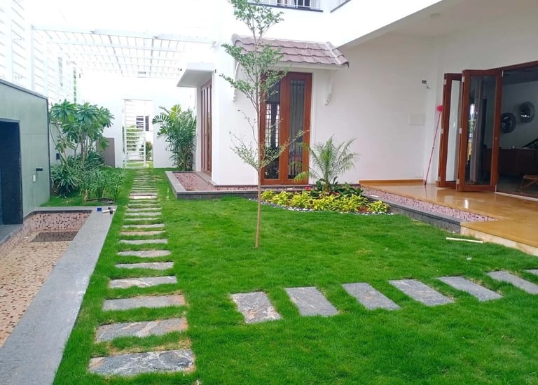 Residential landscape with lush green lawns and flowering borders designed by Garden Designers