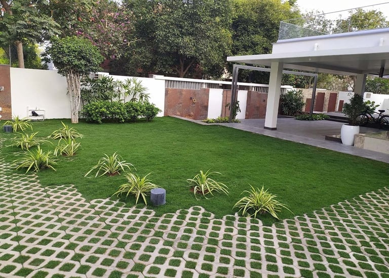 Modern residential garden with layered planting and cozy seating zones by Garden Designers