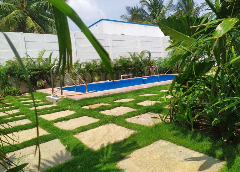 Tropical resort garden with poolside greenery and palm trees by Garden Designers