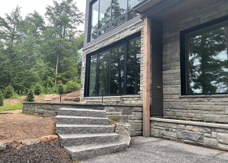Modern home exterior featuring square pattern stone veneer walls.