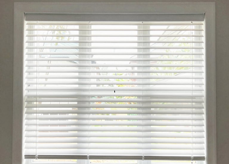 Cozy living room with freshly installed wooden blinds filtering soft sunlight.