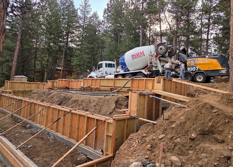Workers preparing concrete wall forms for a structural residential foundation pour.