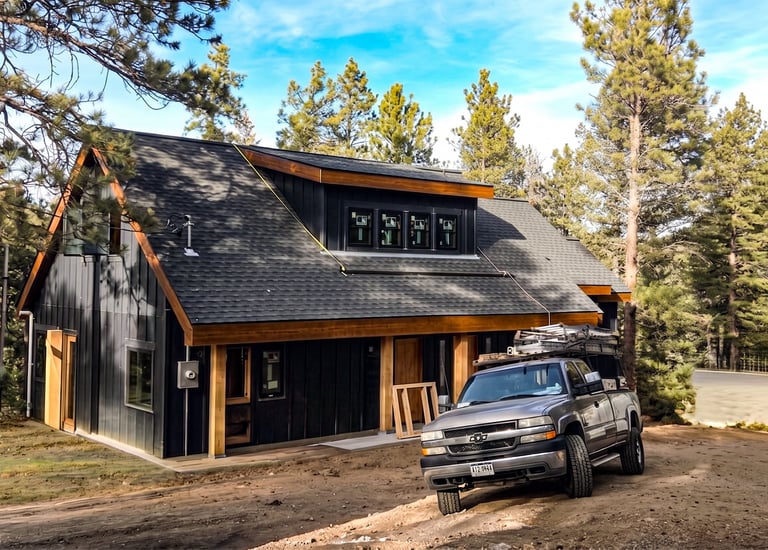 Modern detached garage with dark siding and wood trim built by Elk Valley Contractors in Evergreen, Colorado.
