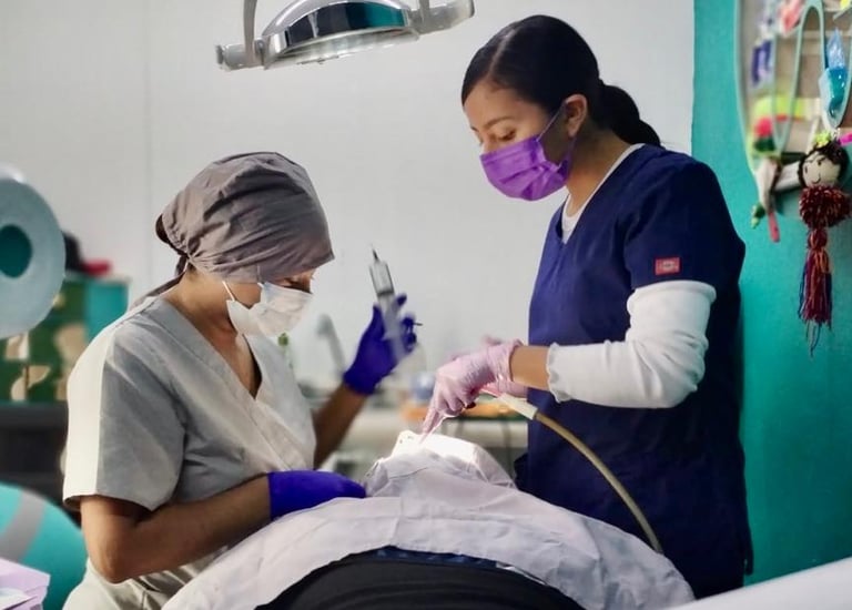 Dos dentistas con herramientas de limpieza dental atendiendo a un paciente