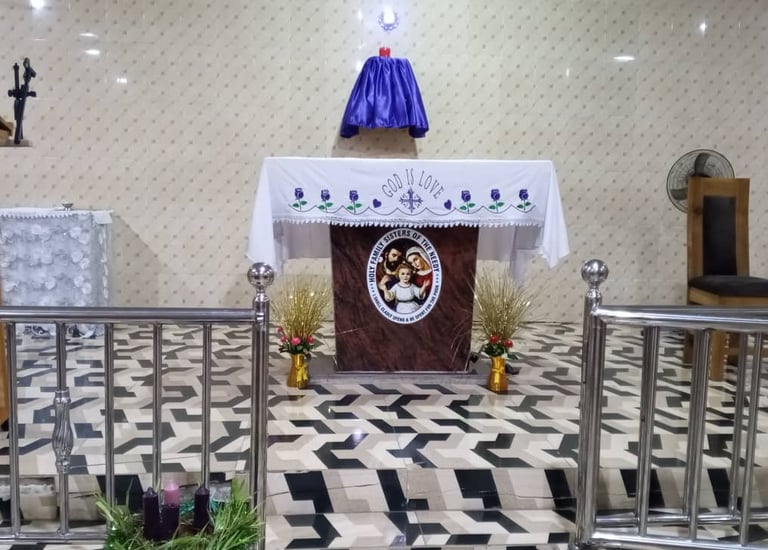 A Catholic church altar with a purple Lenten cloth, religious embroidery, and an Advent wreath.