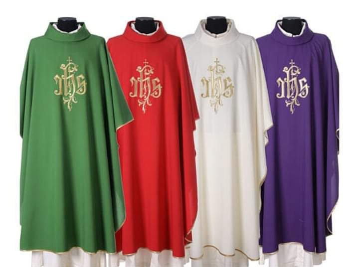 A set of liturgical chasubles in green, red, white, and purple with gold IHS embroidery for church clergy.