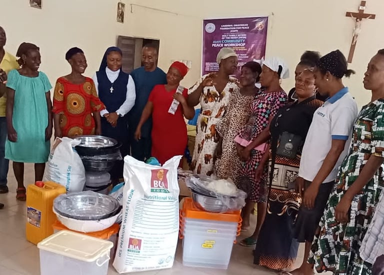 Community Outreach workshop attendees gather around donated food supplies and household goods.