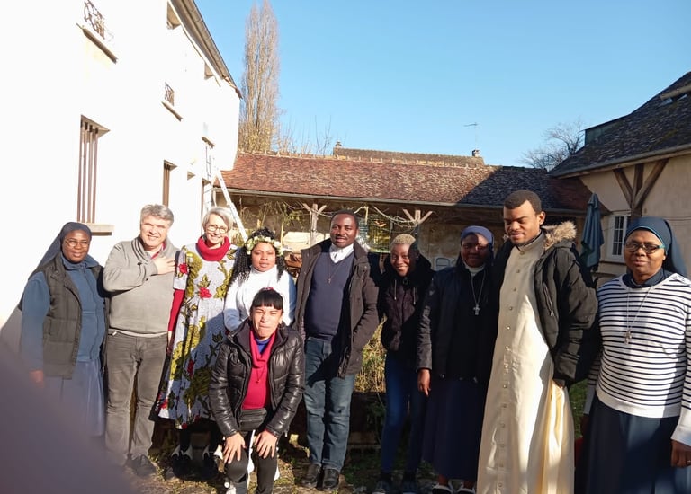 A diverse group of priests and nuns standing together outdoors in a sunny courtyard.