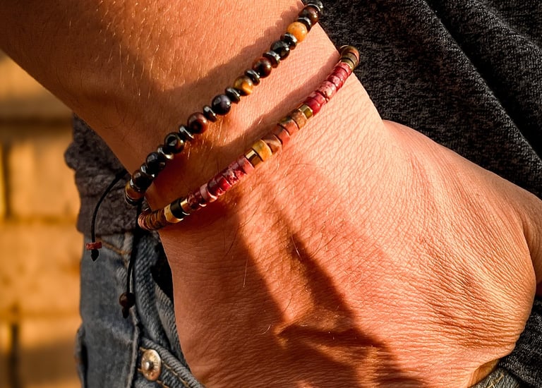 mano con pulseras de piedras en la bolsa de jeans