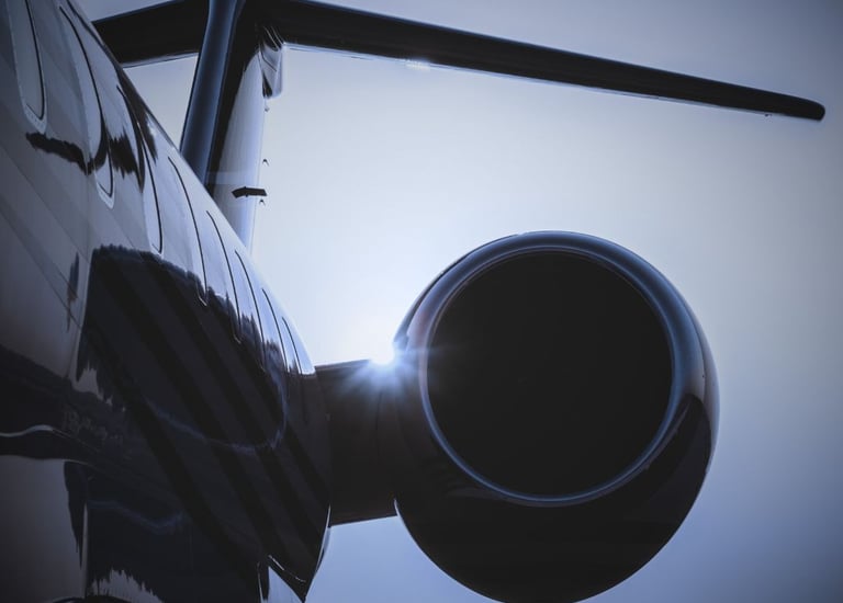 "Private jet engine and aircraft wing with dramatic sky and sunlight"