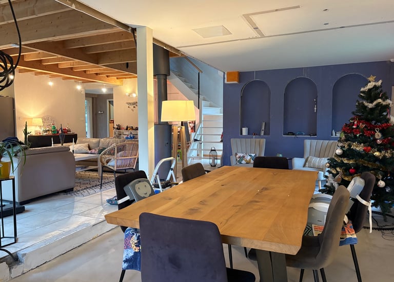 Salle a manger avec table en bois, poutre et arche