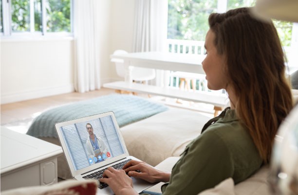 a woman sitting on a couch with a laptop computer