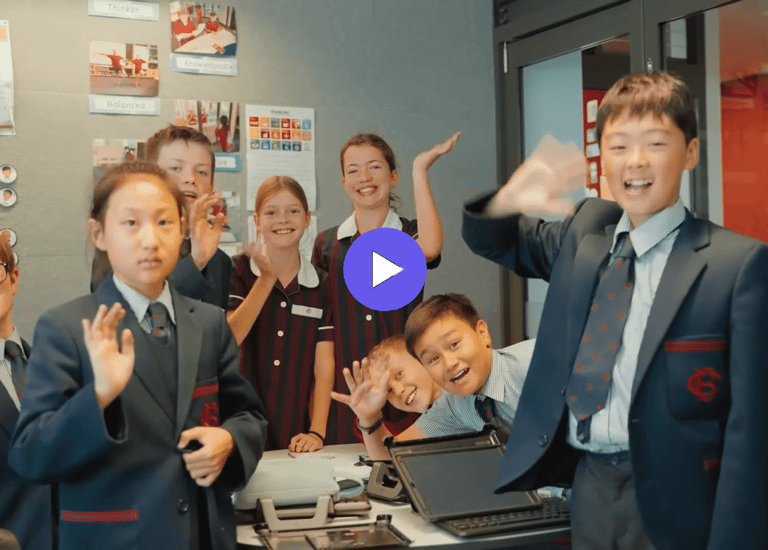 children in school uniforms waving to the camera