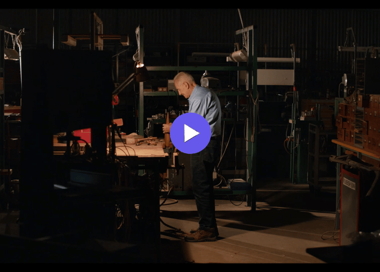 an man in a work shop with a blue shirt